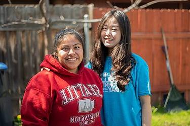 two girls standing together for picture at tri college day event